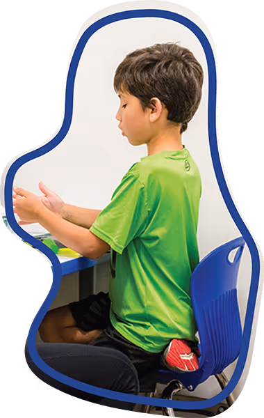 Pediatric therapy client sitting at a table engaging in therapeutic play