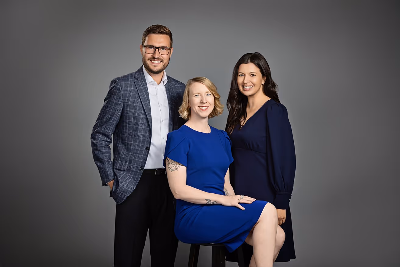 A photo of the team at KASPRE Consulting showing 1 male with glasses and 2 females one with blonde hair and the other with dark hair standing together smiling.