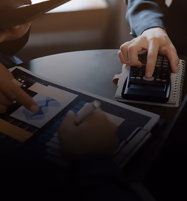 Business team reviewing financial charts with a calculator and notebook
