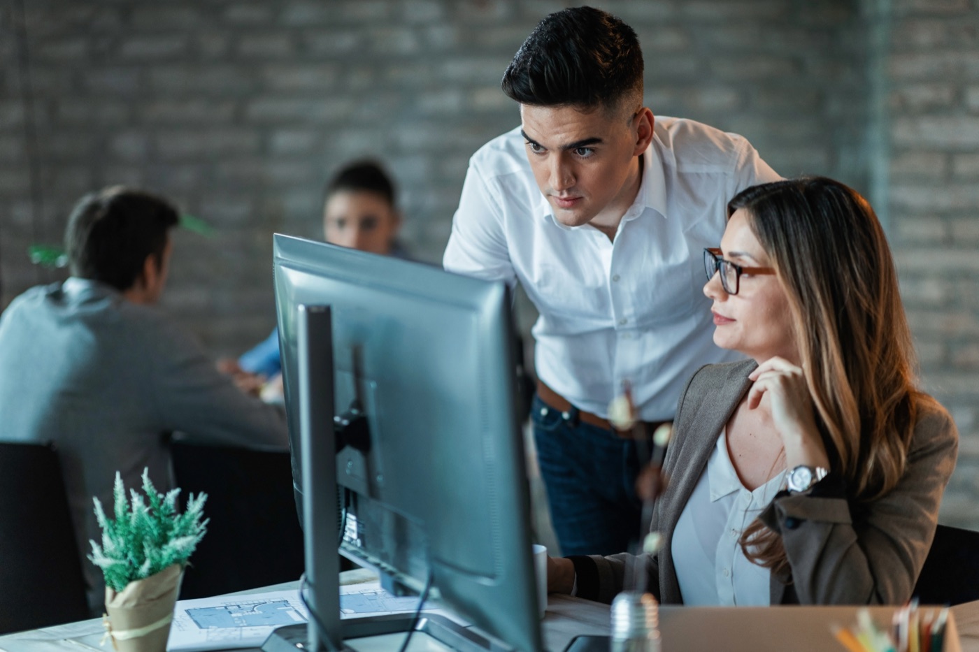 Two engineers reviewing code together at a workstation