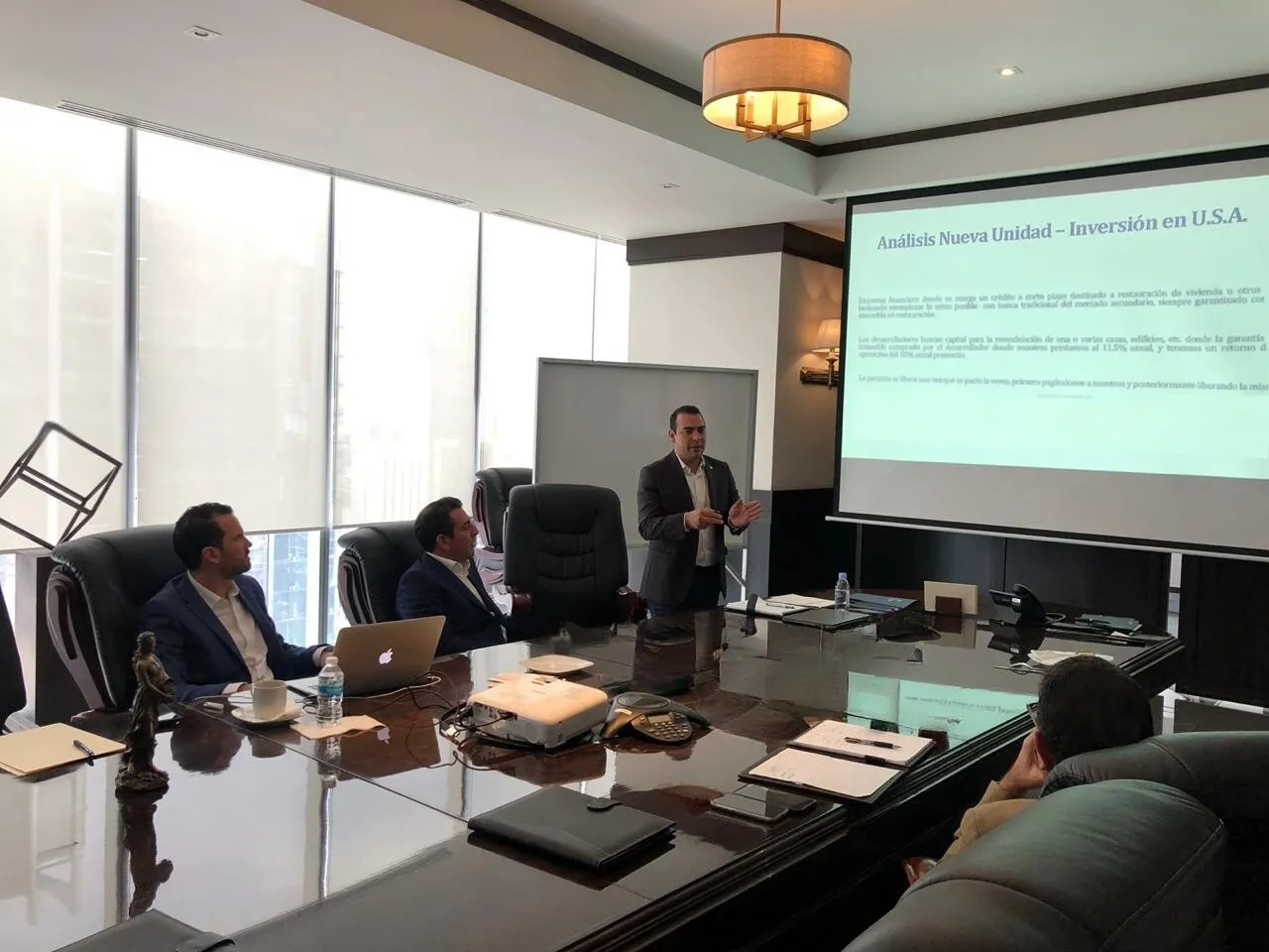 Black Marlin Group owners in a boardroom meeting reviewing U.S. investment analysis presentation.