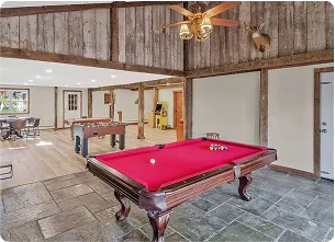 An Image of a Rustic recreation room with a Pool Table