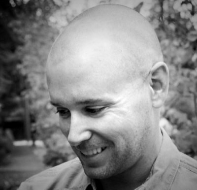 A man with a bald head and a smile on his face.