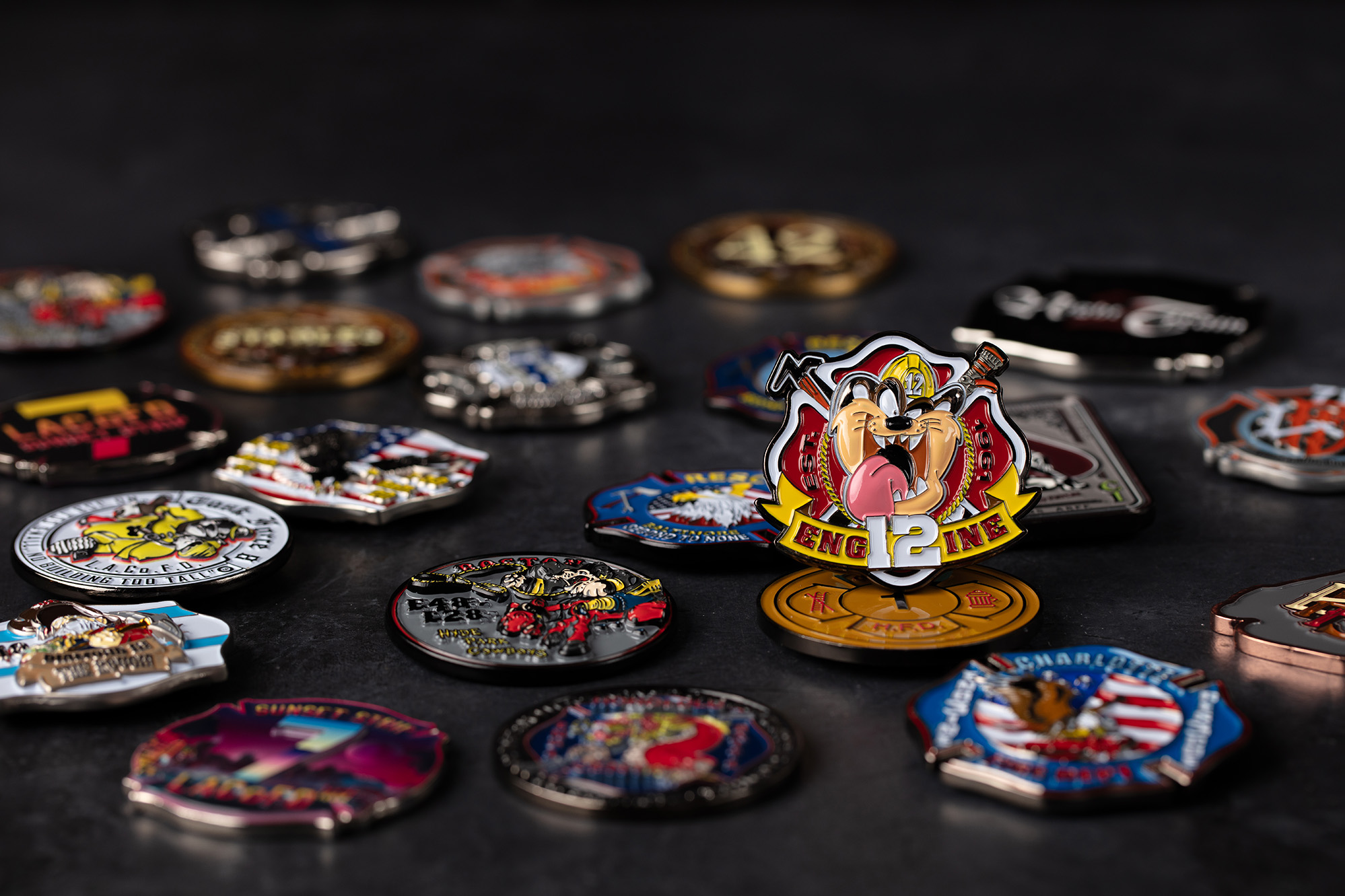 A pile of custom challenge coins, focussed on a coin on the right of the pile
