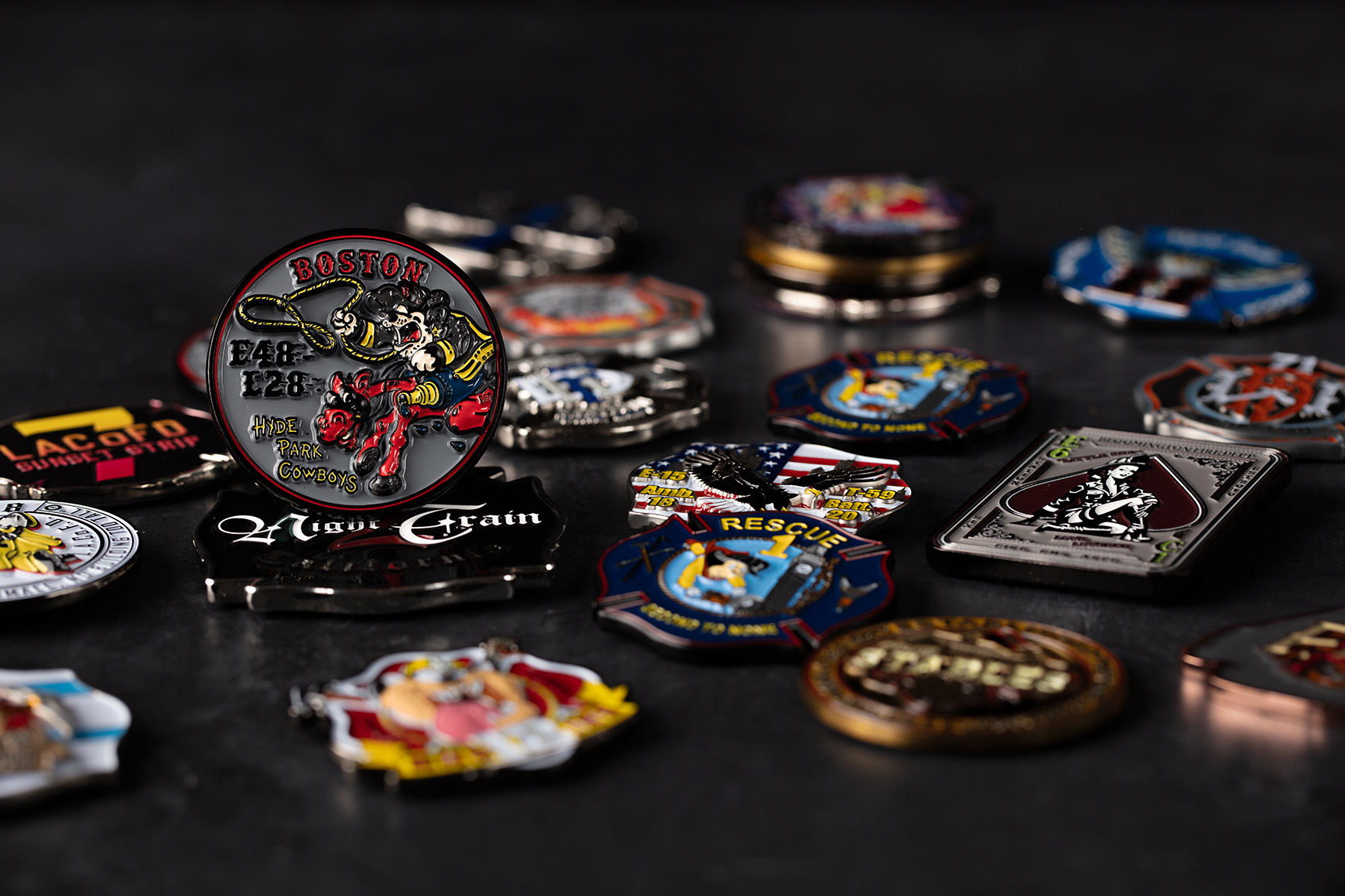 A pile of custom challenge coins, focussed on a silver coin to the left