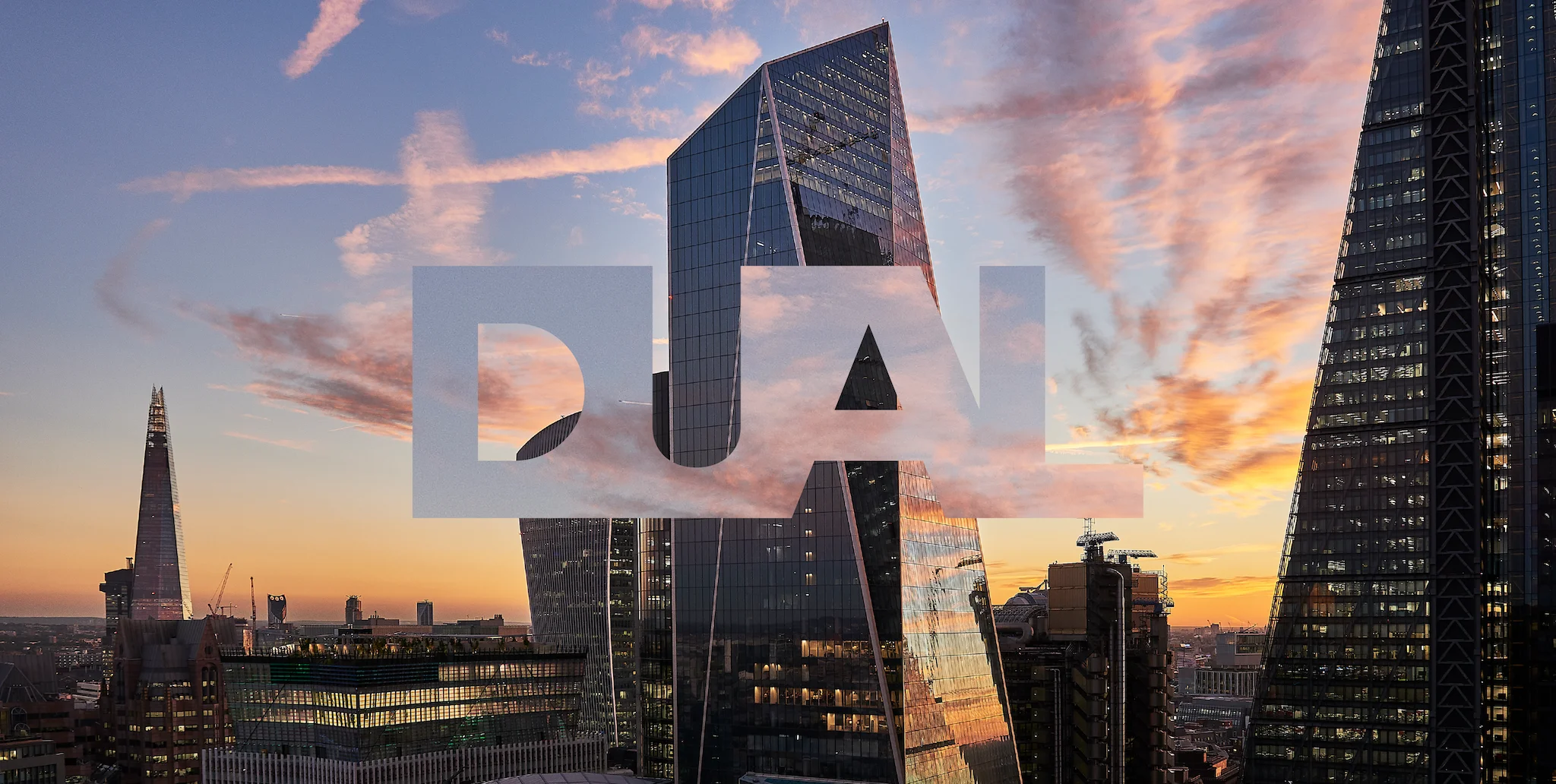 Skyscrapers reflecting sunset sky in a cityscape, with the word "DUAL" superimposed in large, transparent letters across the center of the image.