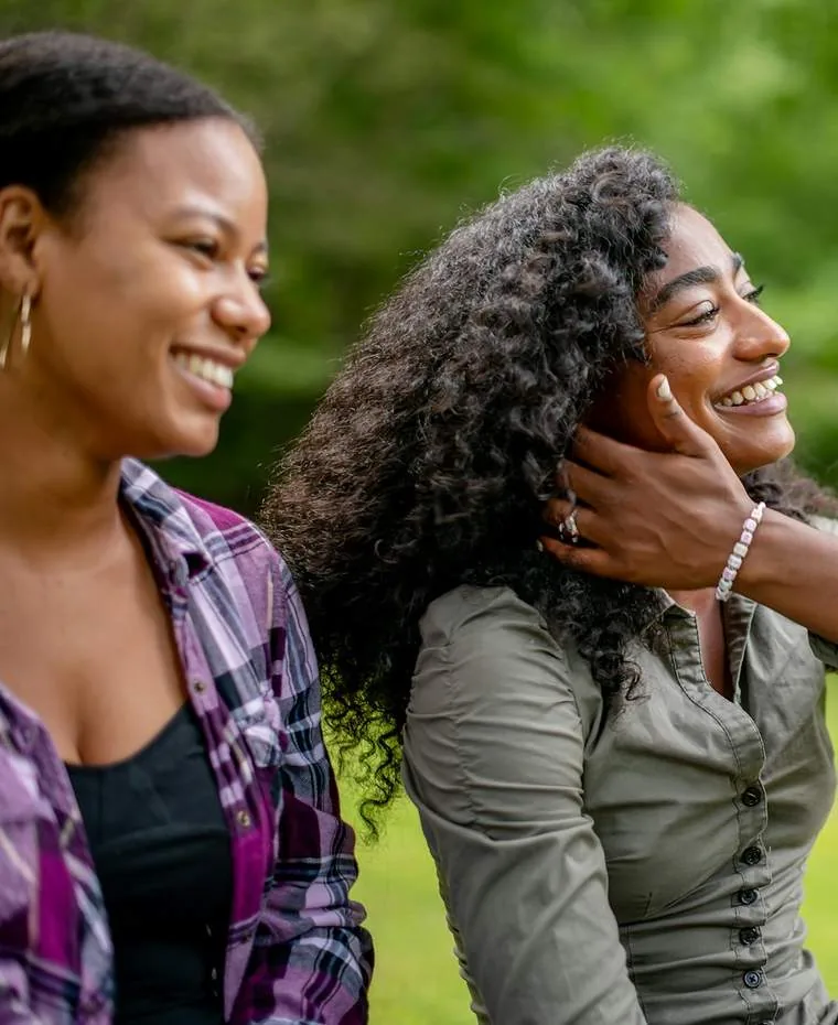 Two friends laughing together in a park