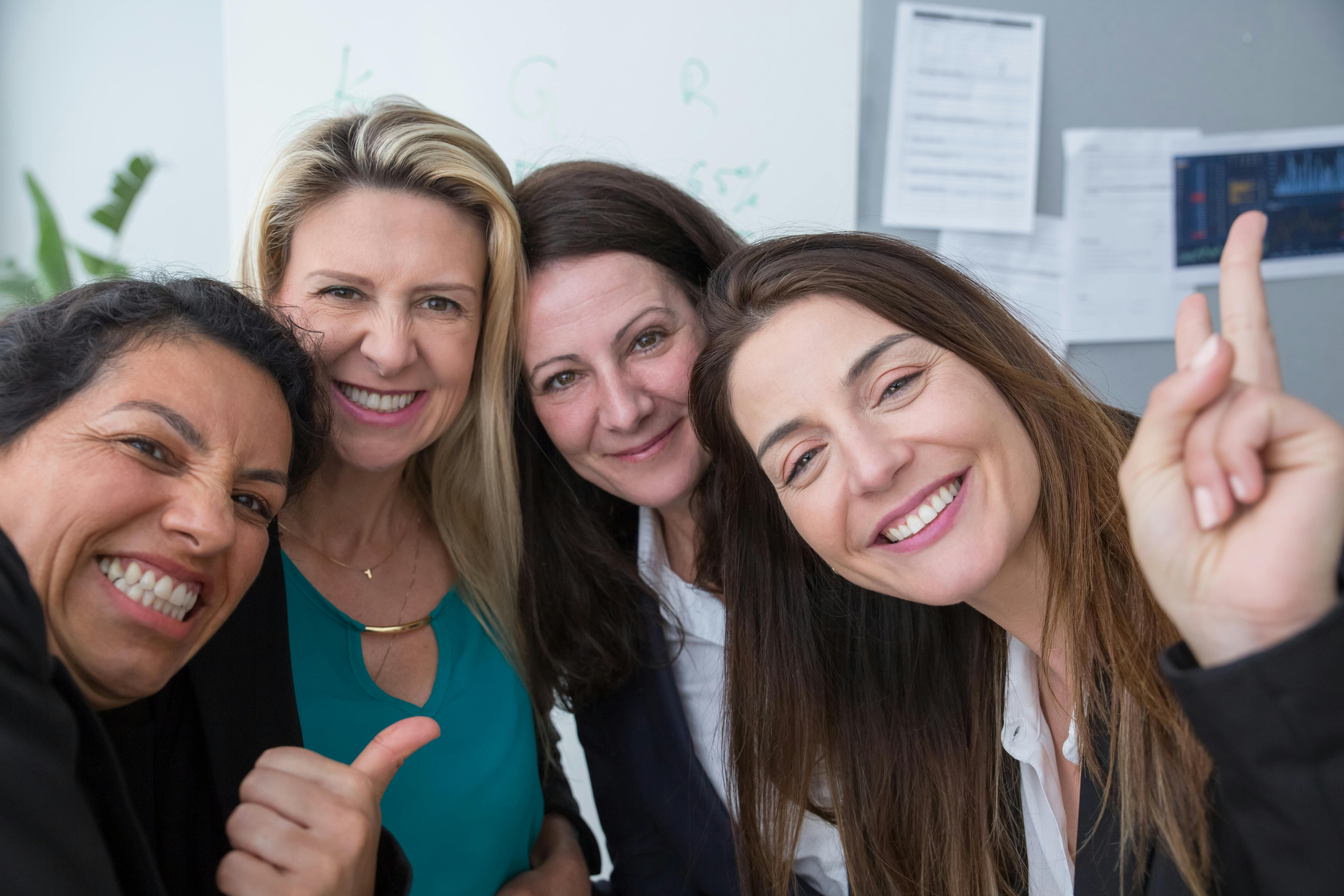 Smiling women posing, showing how to make friends as an adult