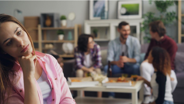 Woman appearing left out during a group gathering in a living room