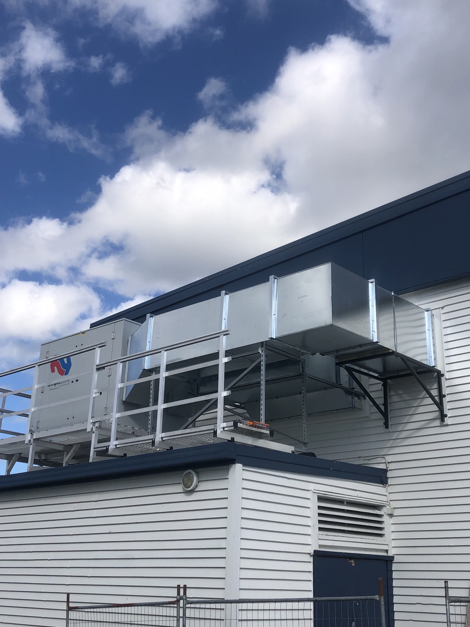Warm It & Cool It vehicle and access equipment at a commercial air conditioning project