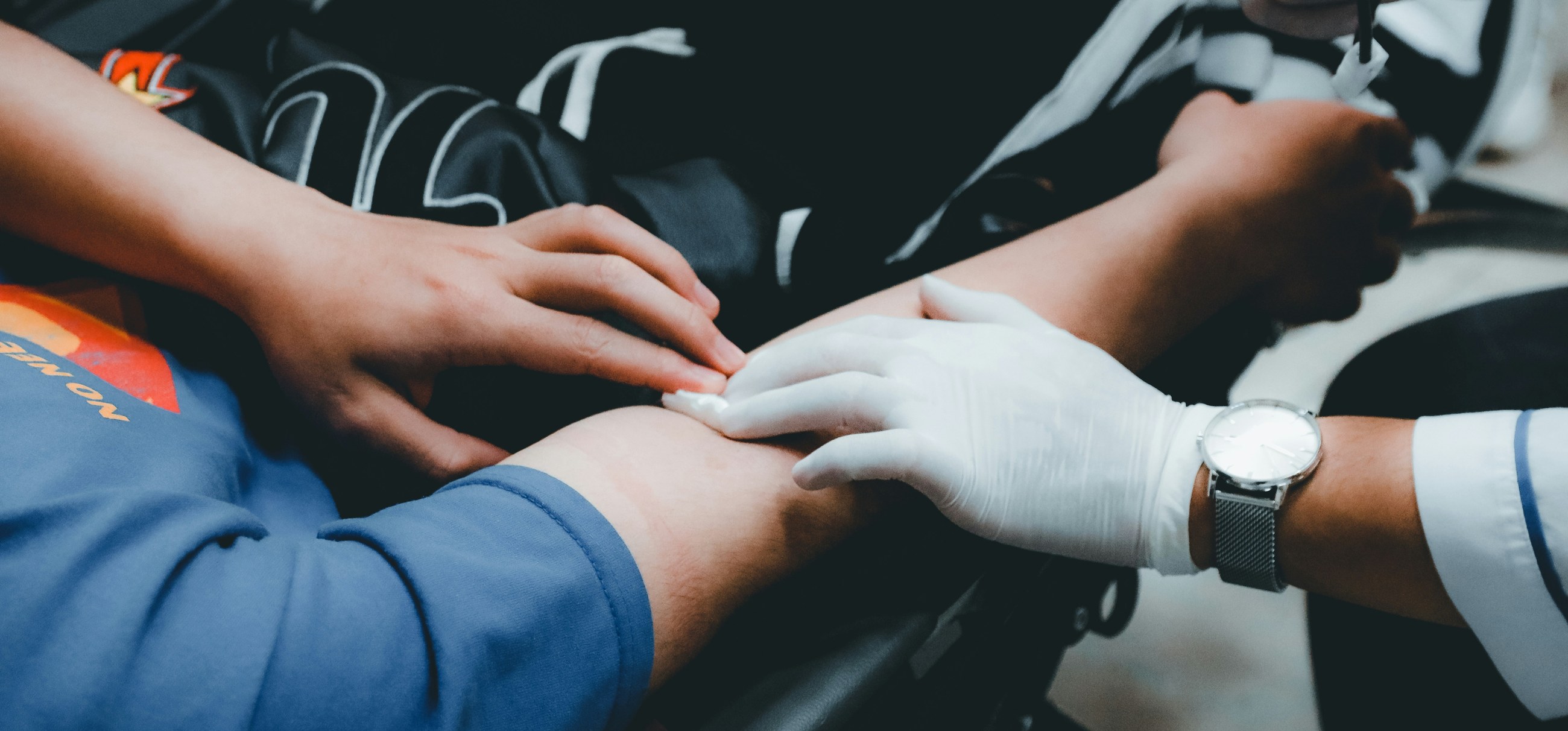 A clinician preparing a patient's arm for a blood draw