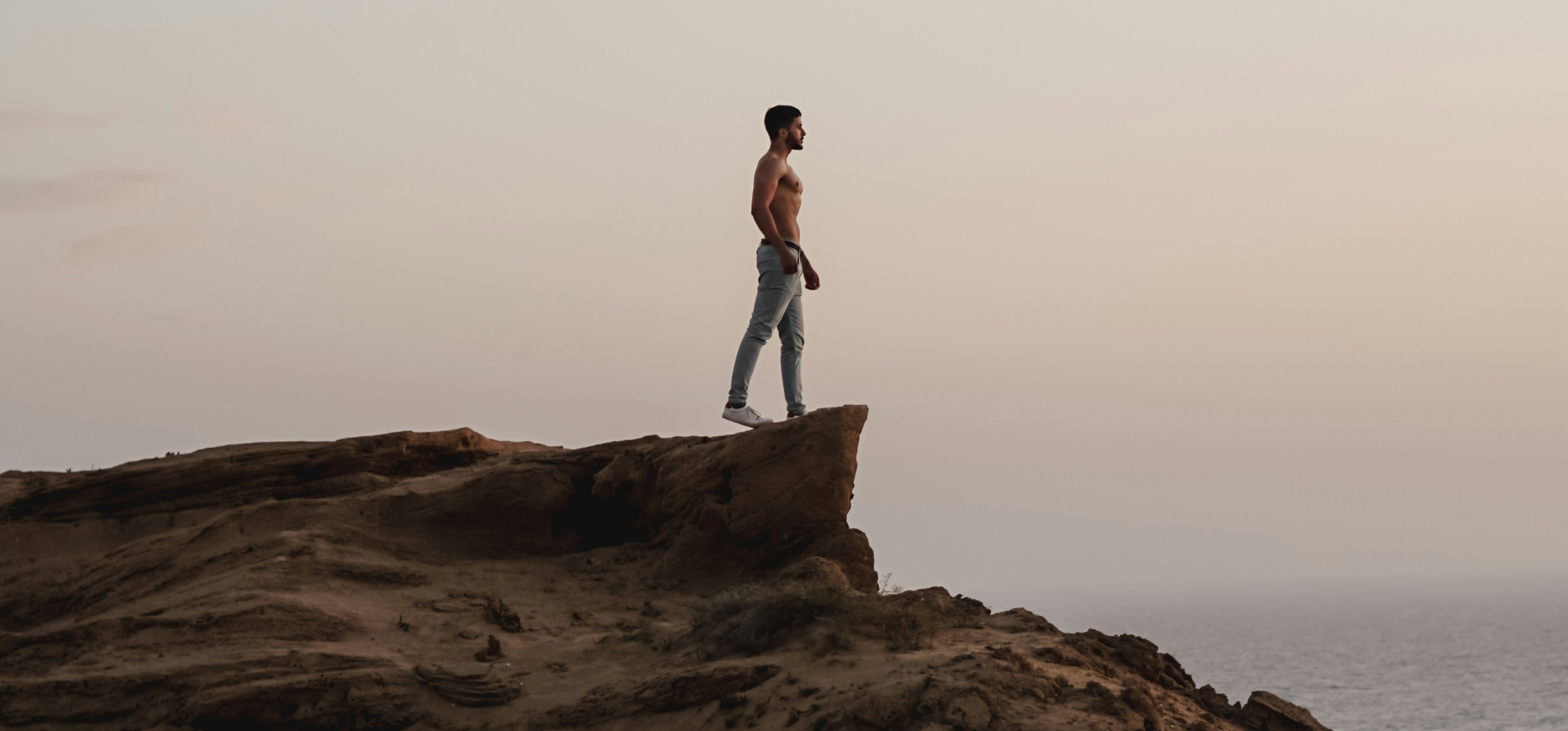 A person standing on a clifftop looking out to sea