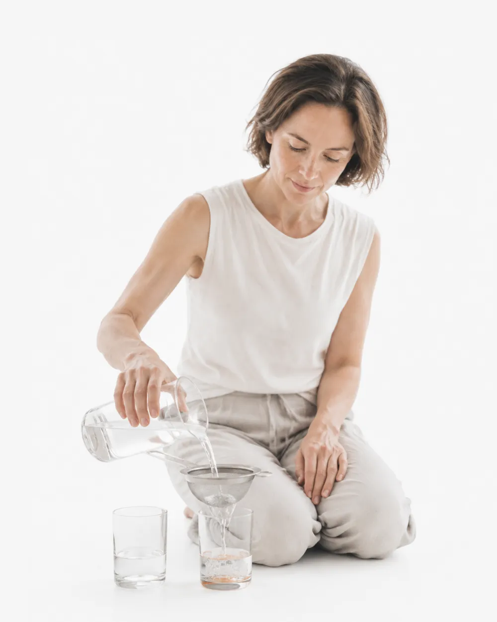 A woman pouring water into a glass, the image for the Aniva cystatin C panel.