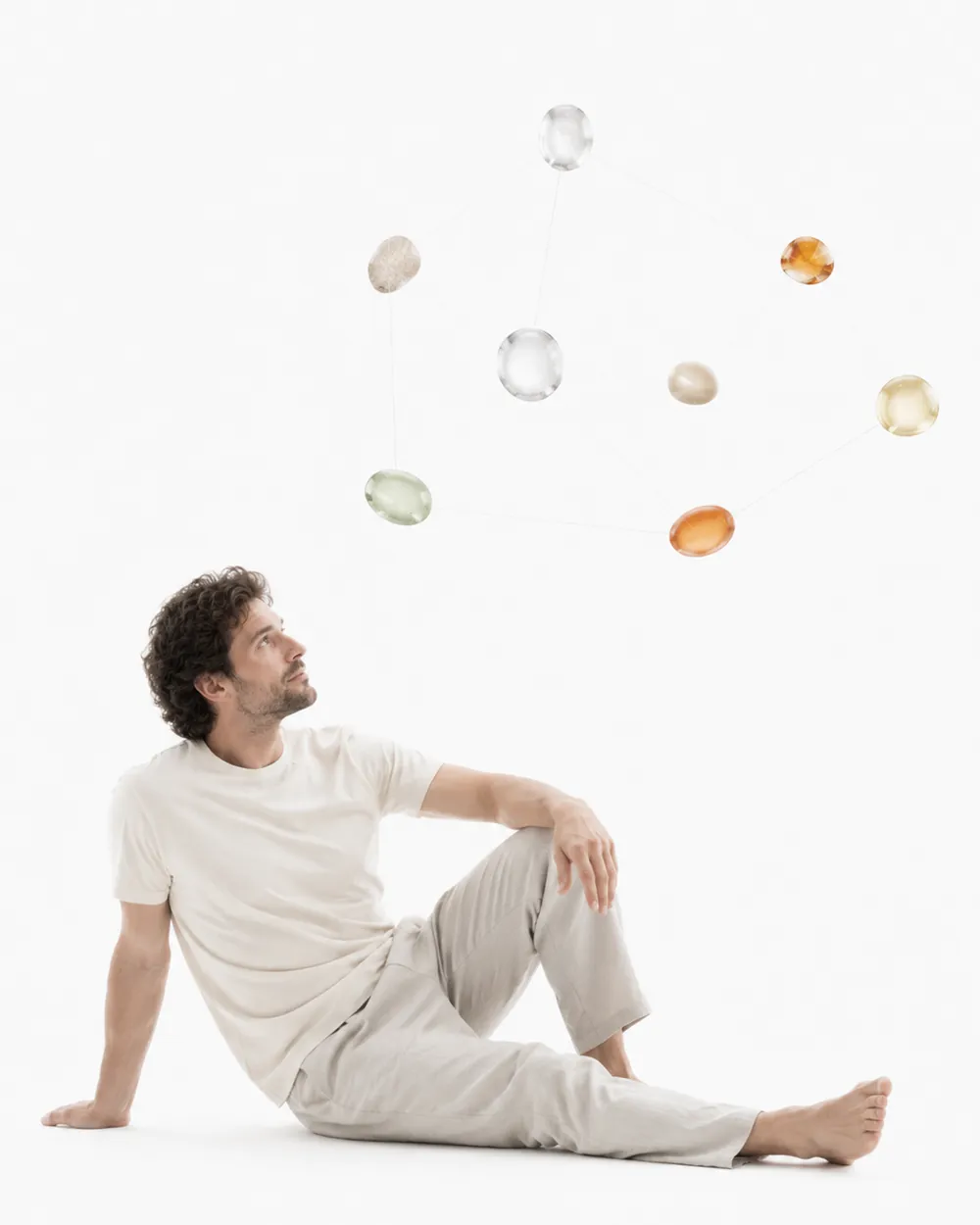 A man reclining below small floating translucent shapes, the image for the Aniva omega-3 index.