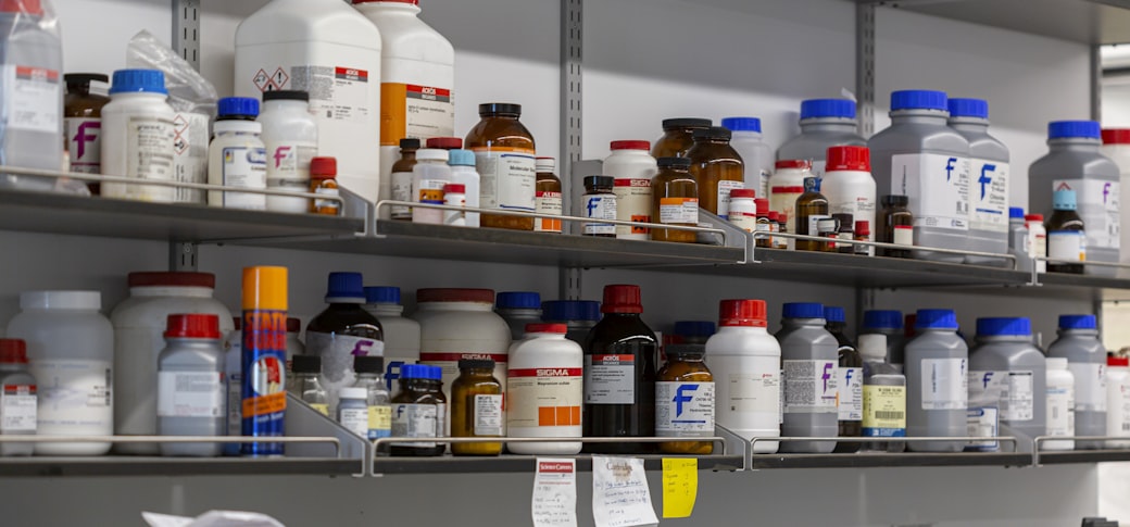 Laboratory shelves holding rows of labelled bottles