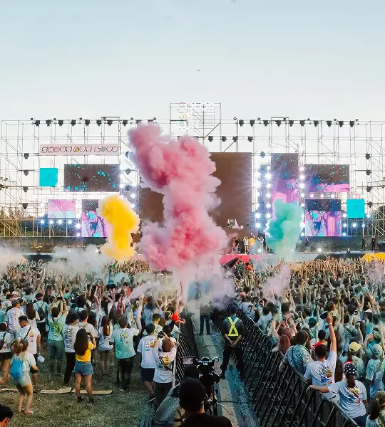 image of a music festival with vibrant colorful smoke