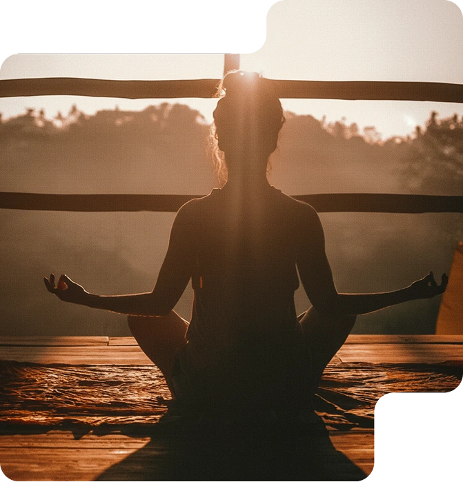 woman meditating on her balcony in front of a forrest