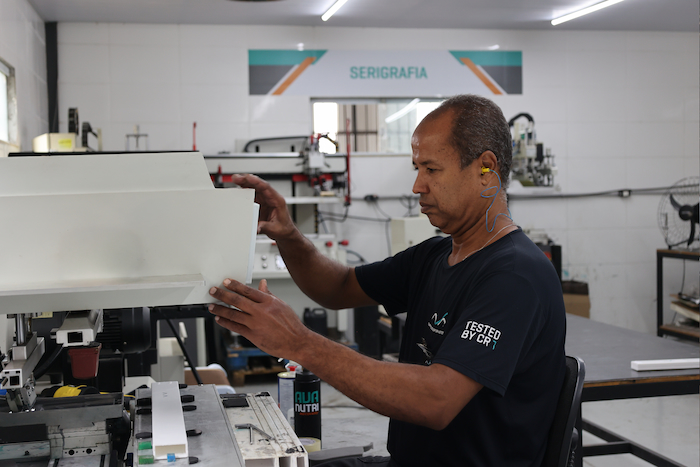 Um homem trabalhando em uma máquina em uma fábrica.