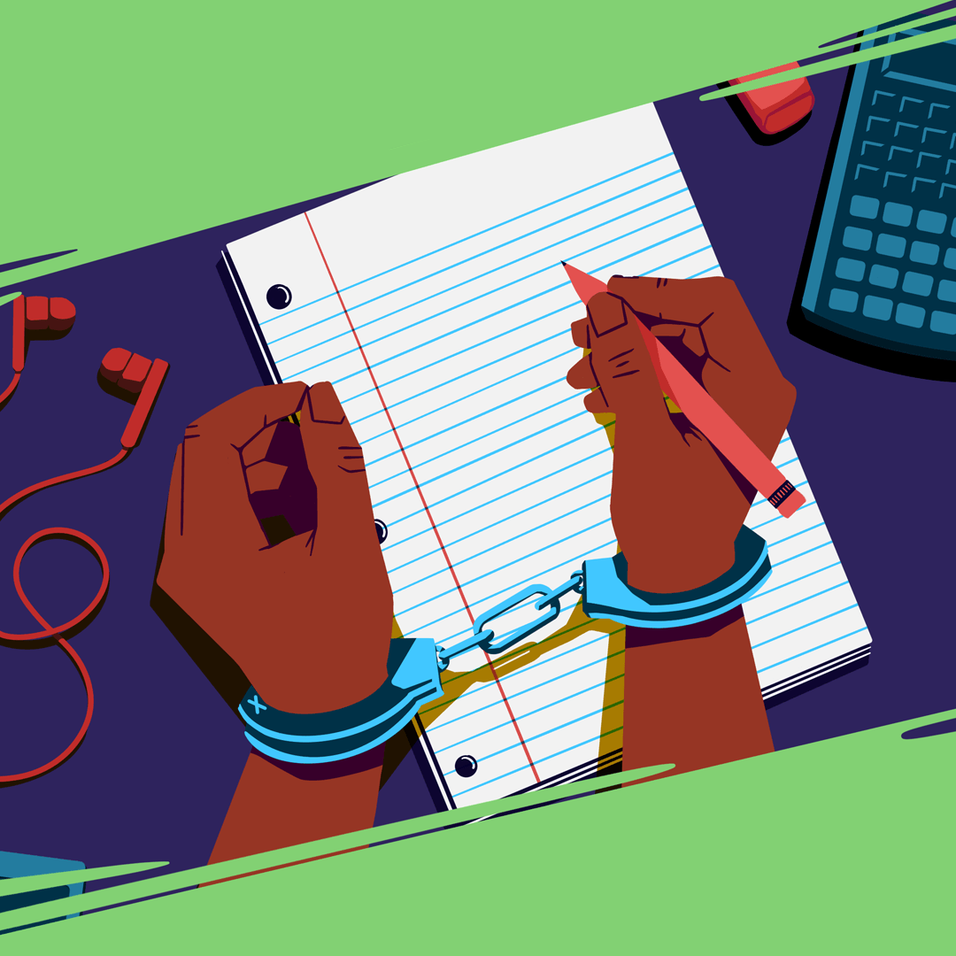 Looking down at a school desk, a student is attempting to write on a notepad while his hands are in handcuffs.