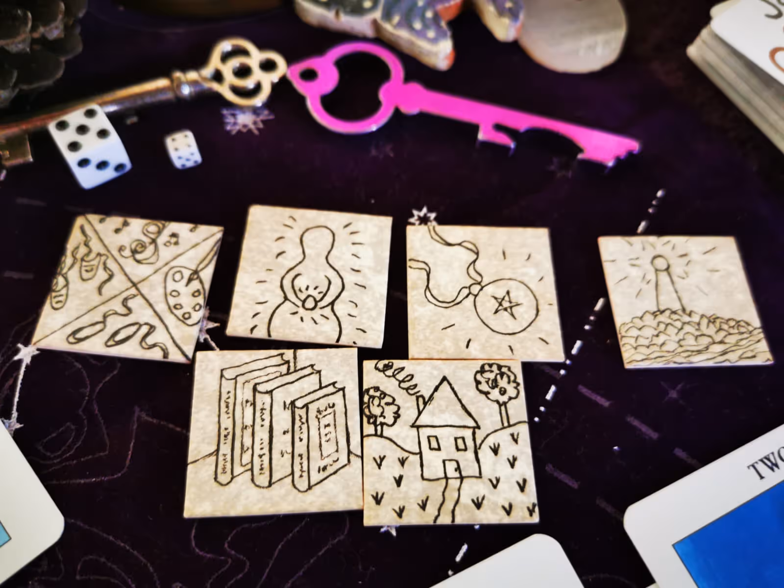 Hand-drawn oracle symbols and tarot cards surrounded by keys, used in a Wiccan synchronicity signs reading.