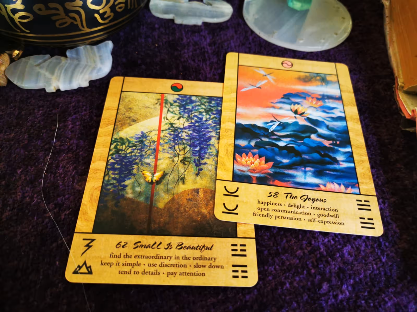 Two Tao Oracle cards on purple cloth: 'Small is Beautiful' and 'The Joyous' offering Wiccan insight on simplicity and happiness.