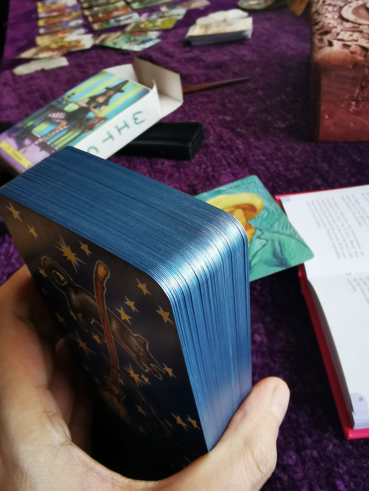 Close-up of Everyday Witch Tarot cards with metallic blue DIY-edged borders on a Wiccan tarot reading table."