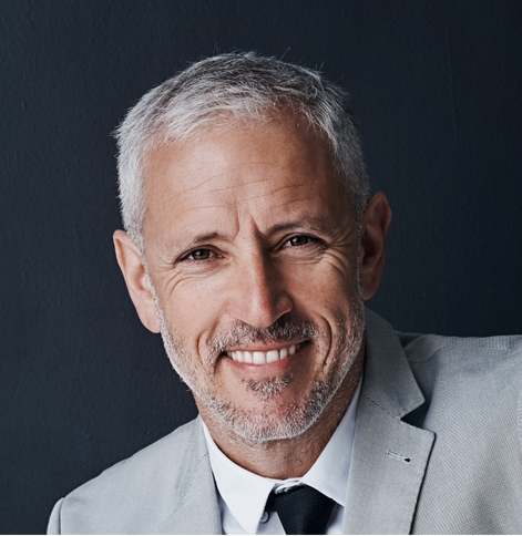 A man in a suit and tie smiling confidently at the camera.