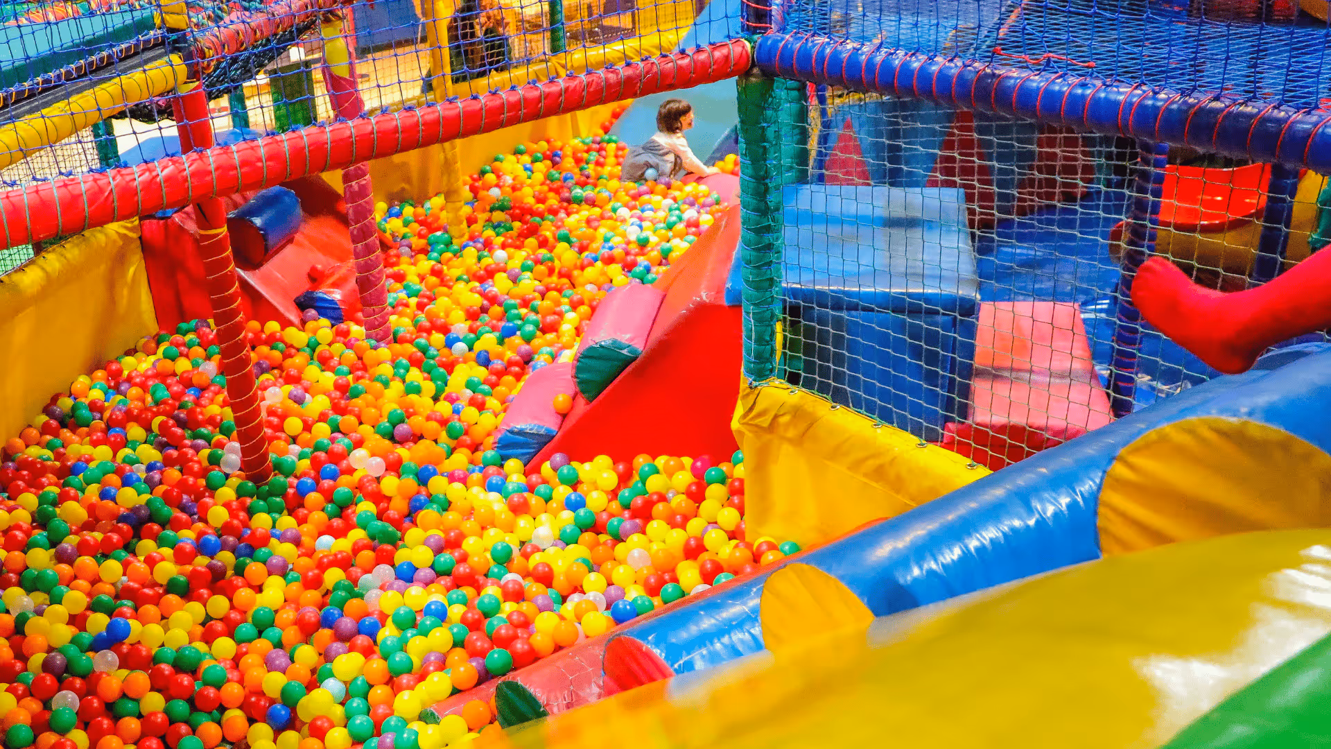 Colorful ball pit with slides and nets in indoor children's playground
