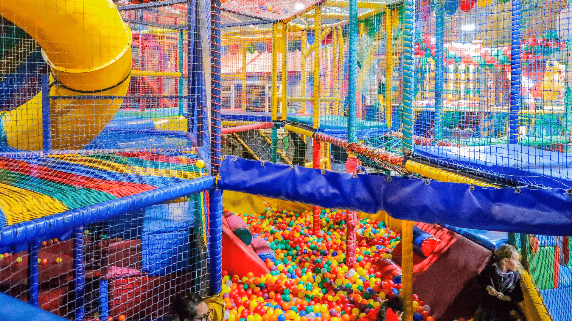 Colorful indoor playground with netted platforms and ball pit