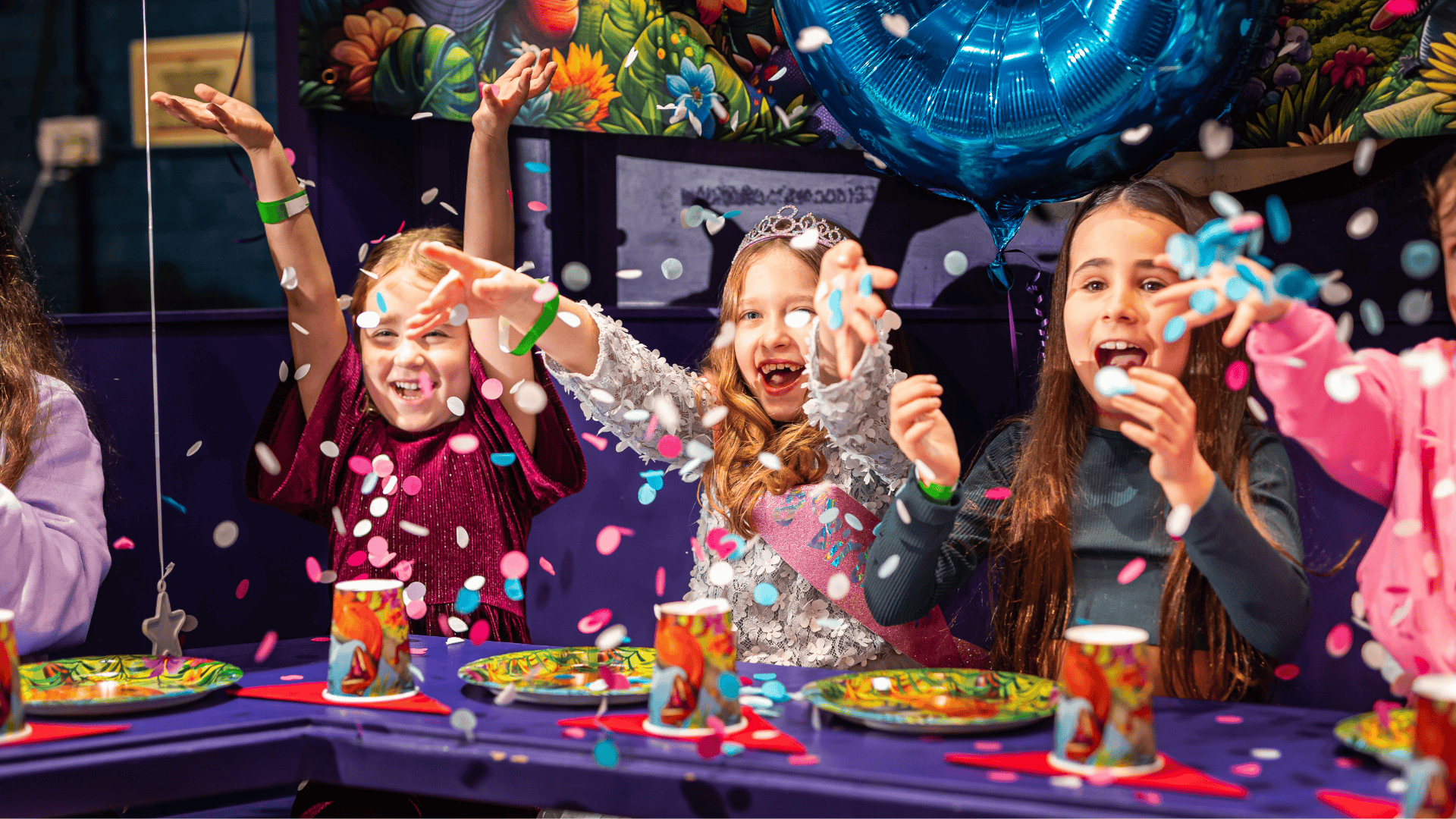 Girls celebrating a birthday with a cake in a Clowntown party area
