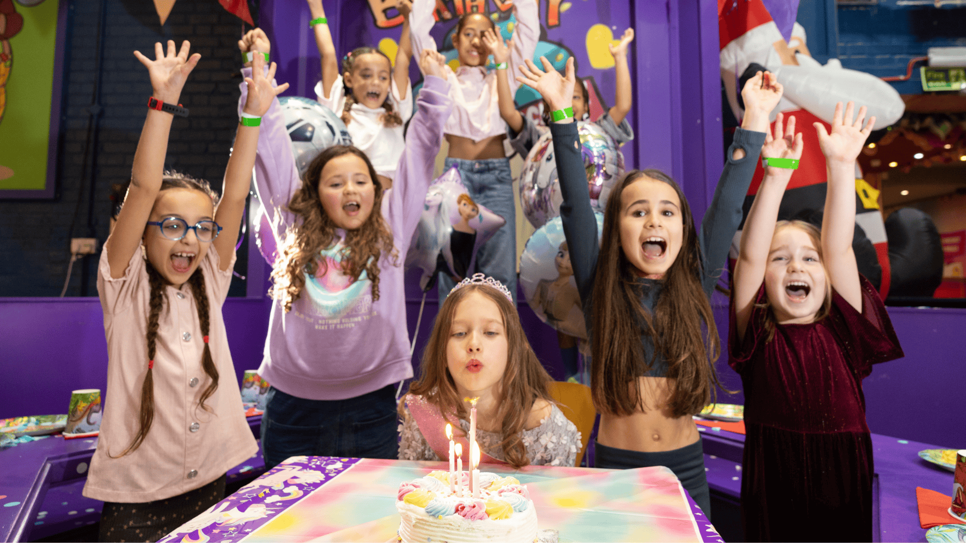 Girls cheering with birthday cake looking happy at a birthday party