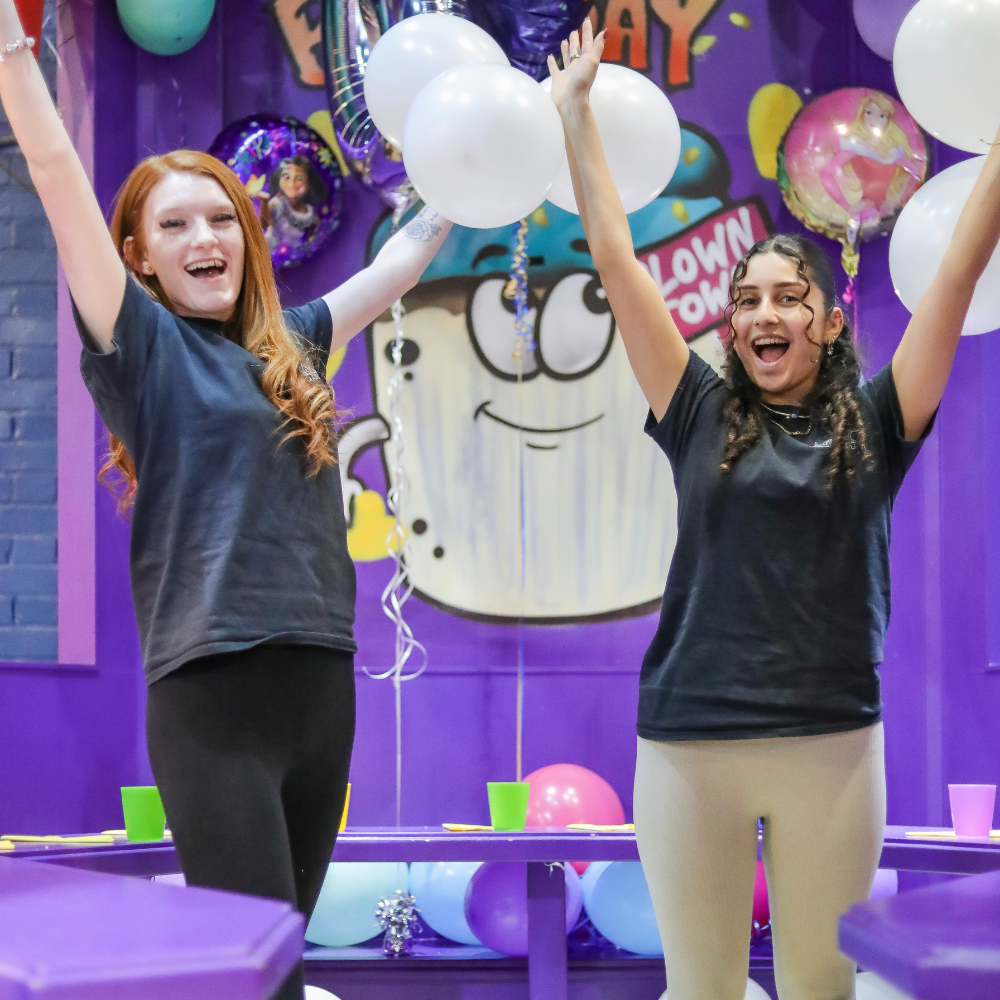Staff members cheering in birthday party area with balloons 