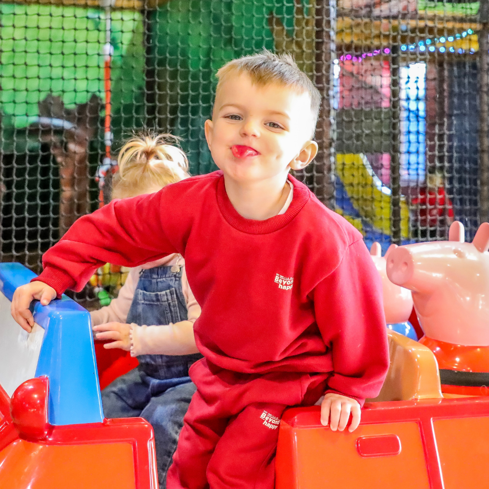A toddle on a peppa pig ride in a softplay centre