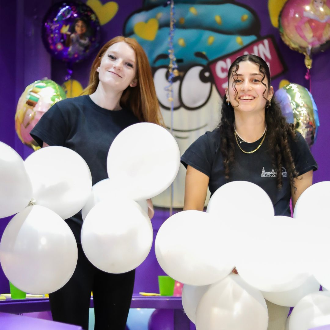 Staff holding balloons celebrating a kids birthday party