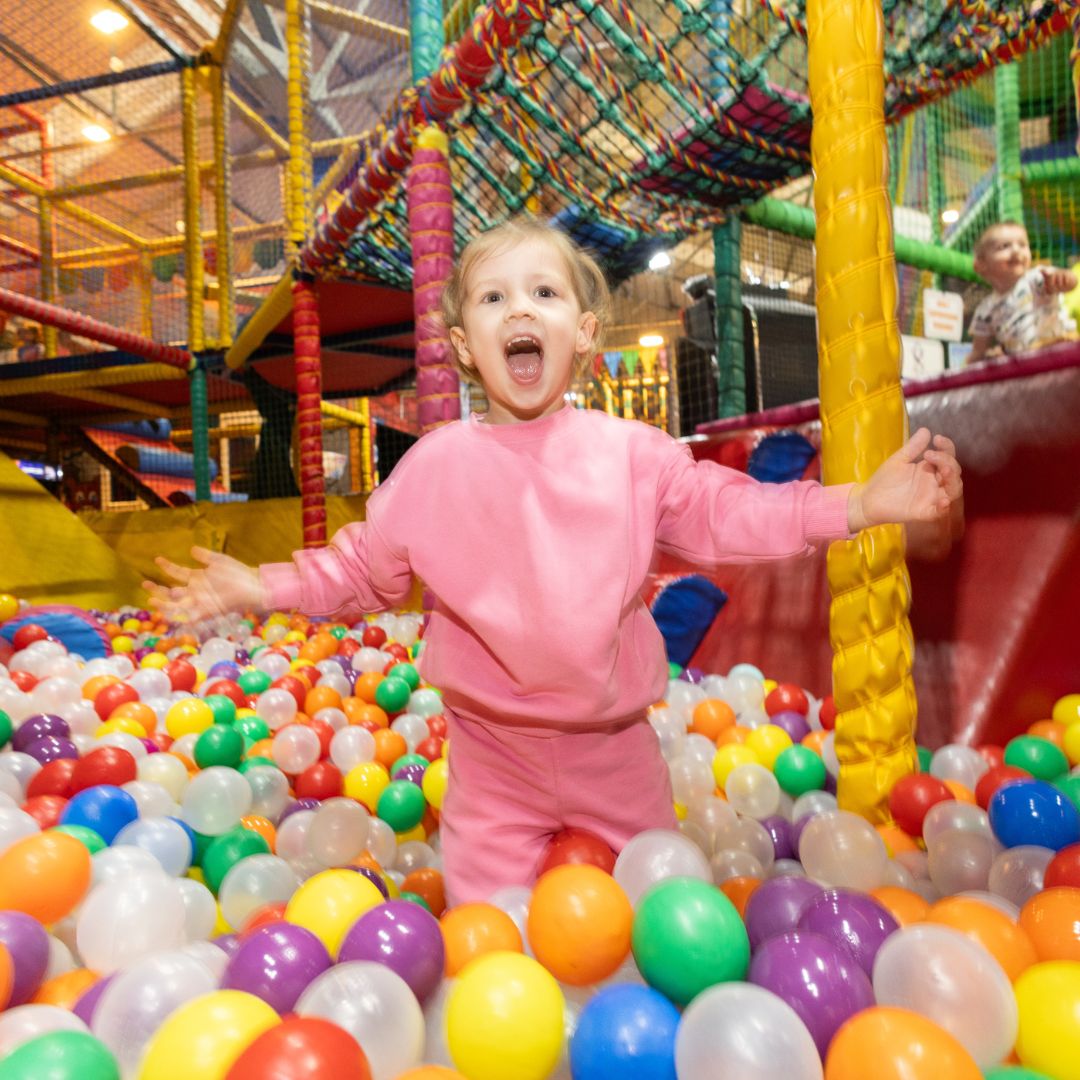 Girld having a lot of fun in a huge ball pool 