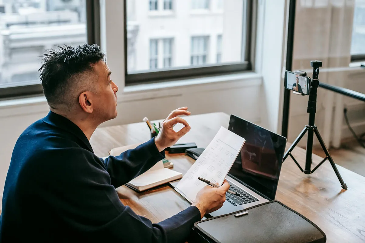 An online tutor is recording a video through his smartphone.