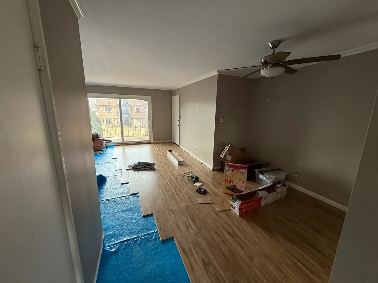 Professional flooring installation in Naperville home – hardwood planks being installed.