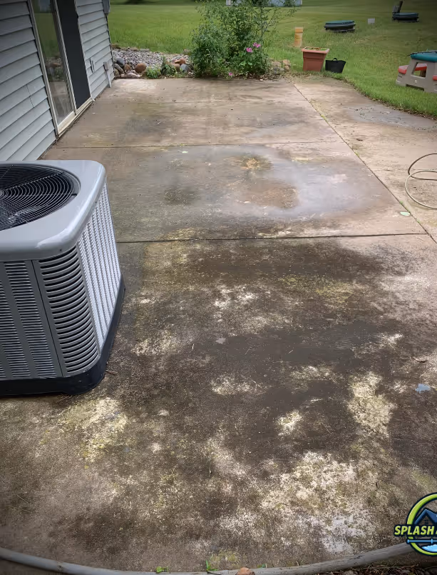 Concrete patio with patches of dirt and moss, before Splash and Shine cleaning