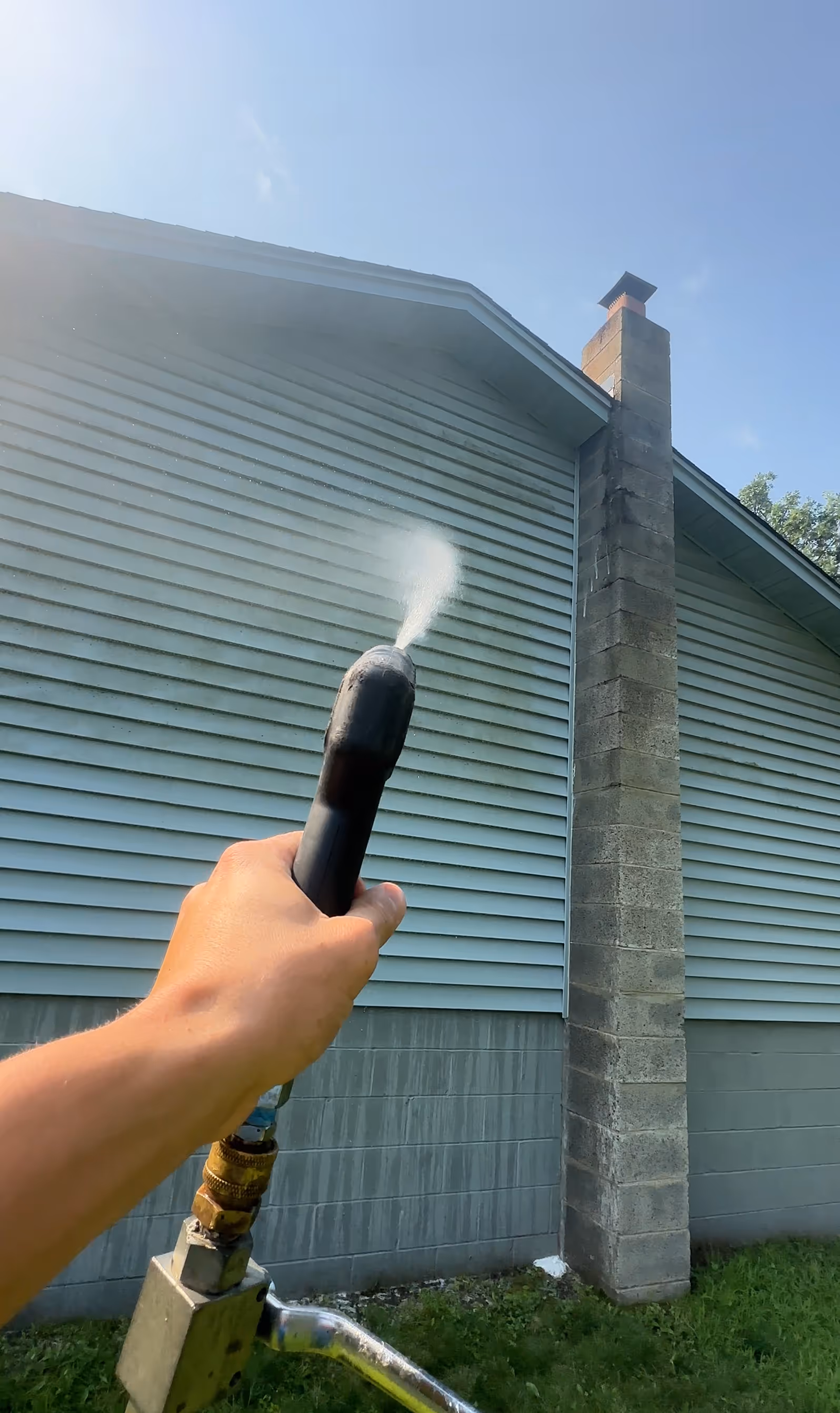 Splash & Shine crew soft washing a home exterior to remove algae and mildew