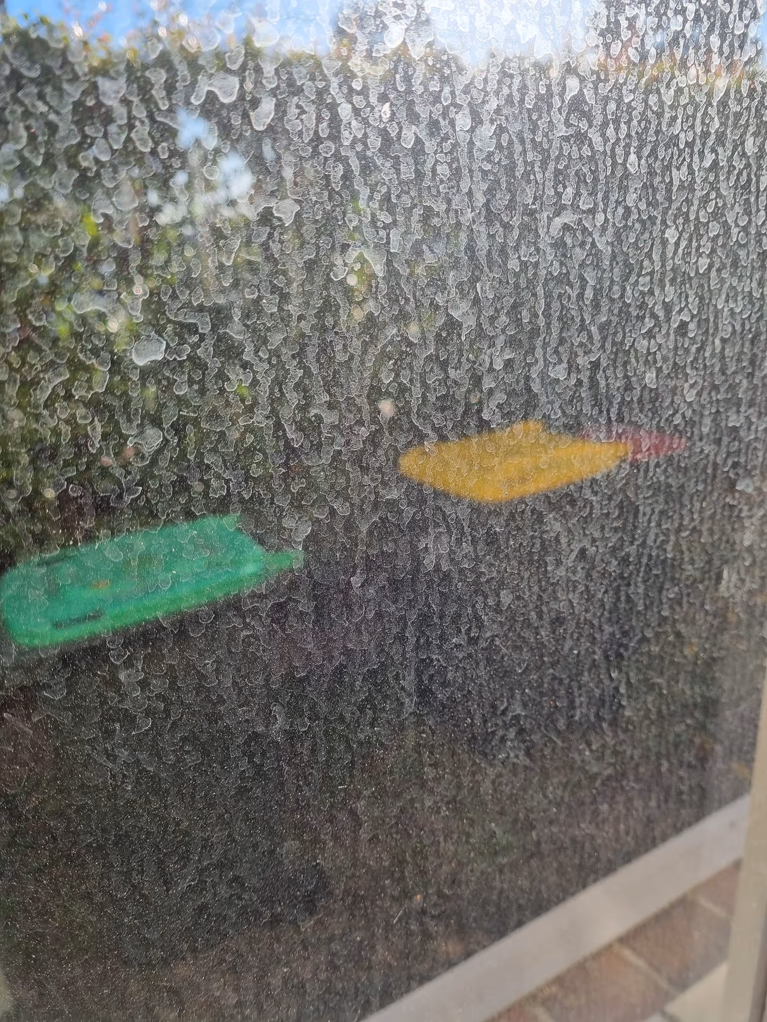 Hazy window glass with mineral spots and streaks before cleaning
