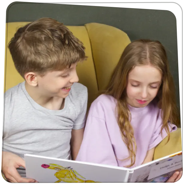 Kisfiú és kislány együtt lapozzák a saját rajzaikból készült Rajzkönyvet.