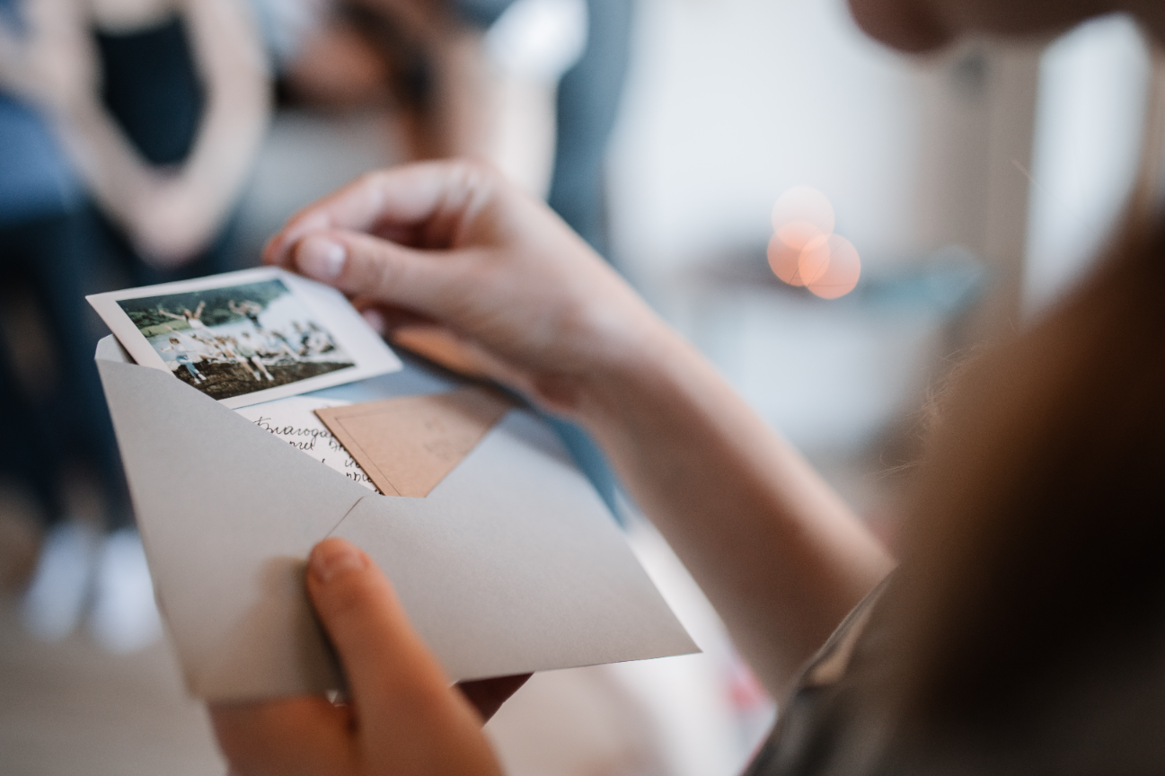 An image of woman opening an mail with photos and small letter. Background blur 