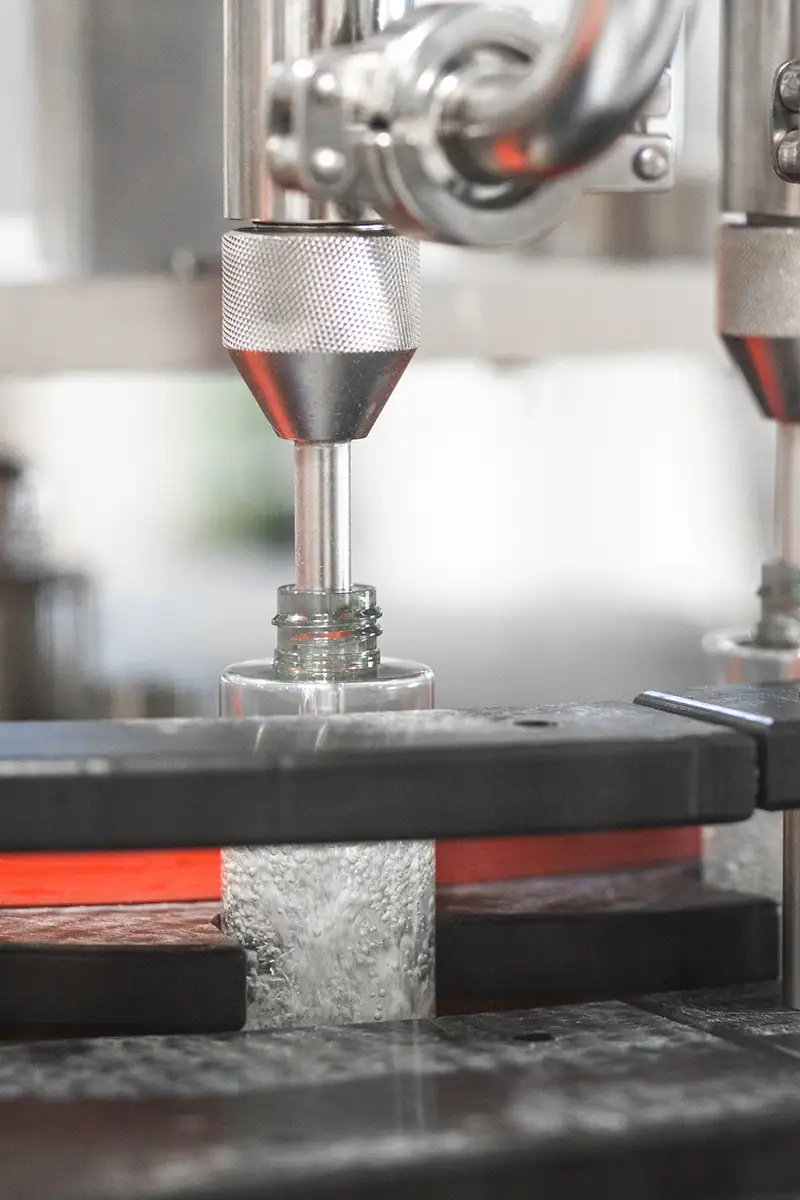 ein Glas wird von einer Maschine befüllt