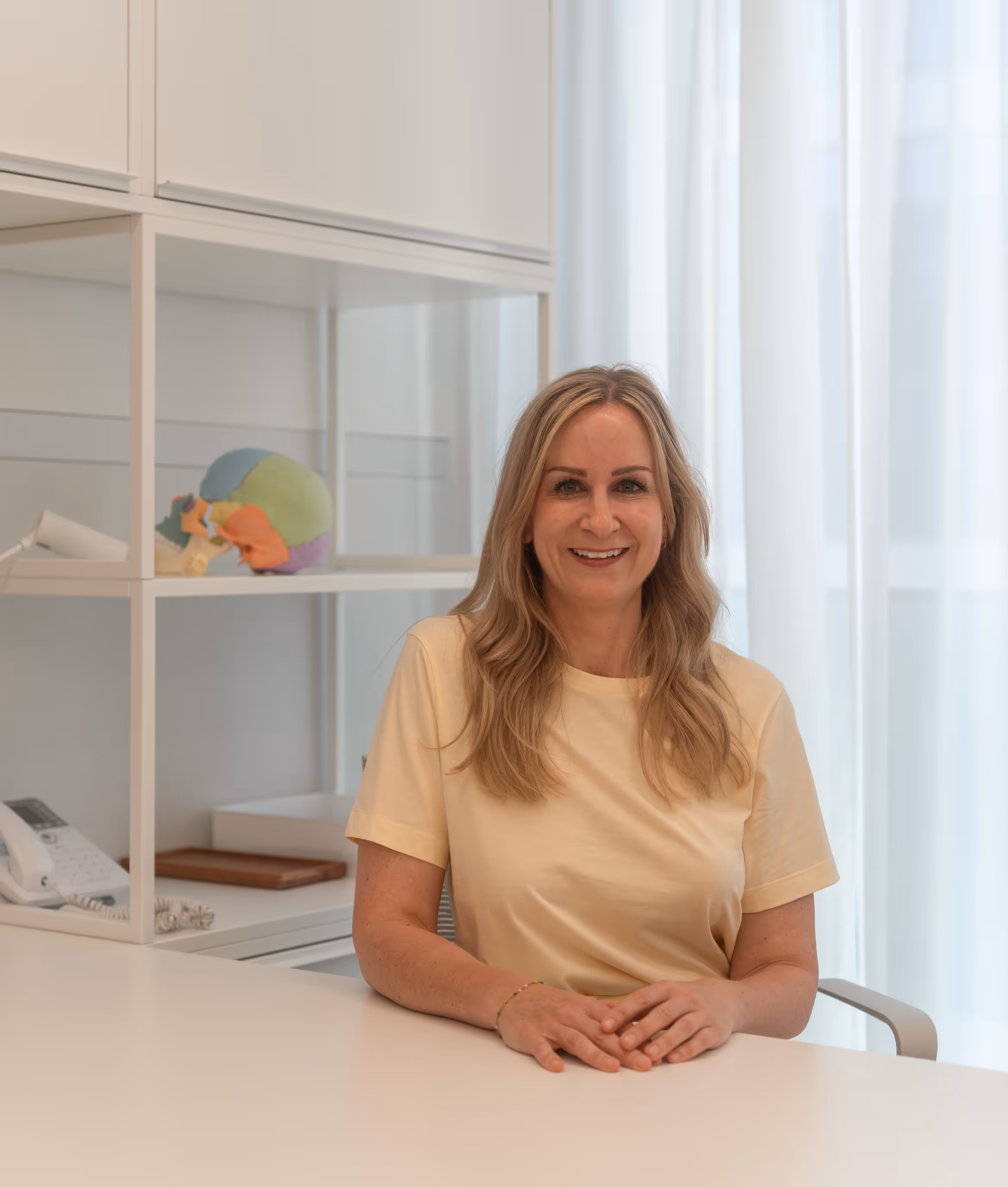 Bild von Kirsten Skopp, wie sie am Schreibtisch sitzt