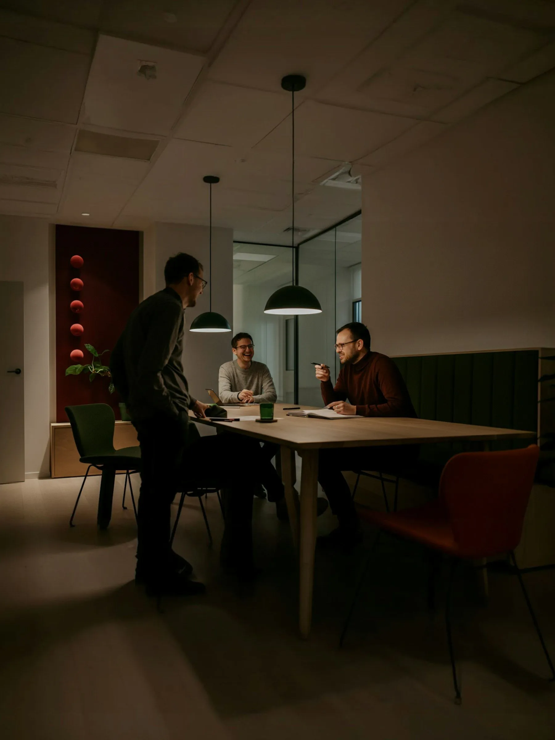 Two men sitting at a table in a dark room.