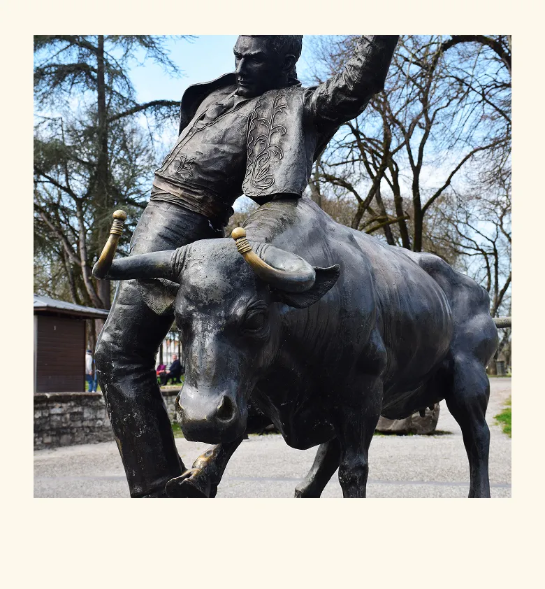 Statue d’un homme avec un taureau en bronze

