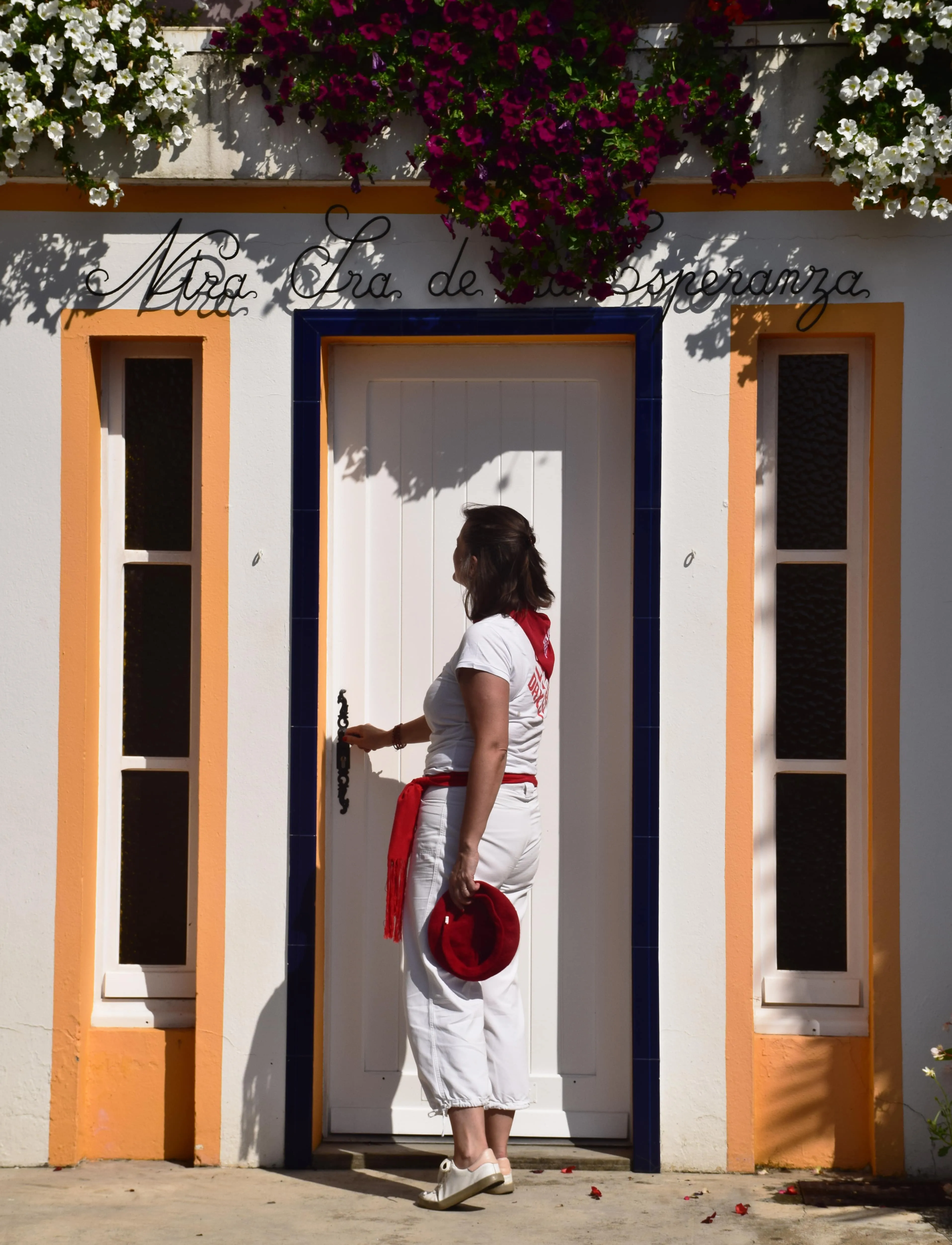 Femme avec un violon devant une porte orange à Dax