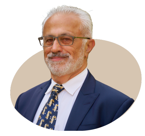 A professional portrait of the director of a private medical insurance brokerage, dressed in a business suit, standing in a modern office setting with a confident and approachable expression.
