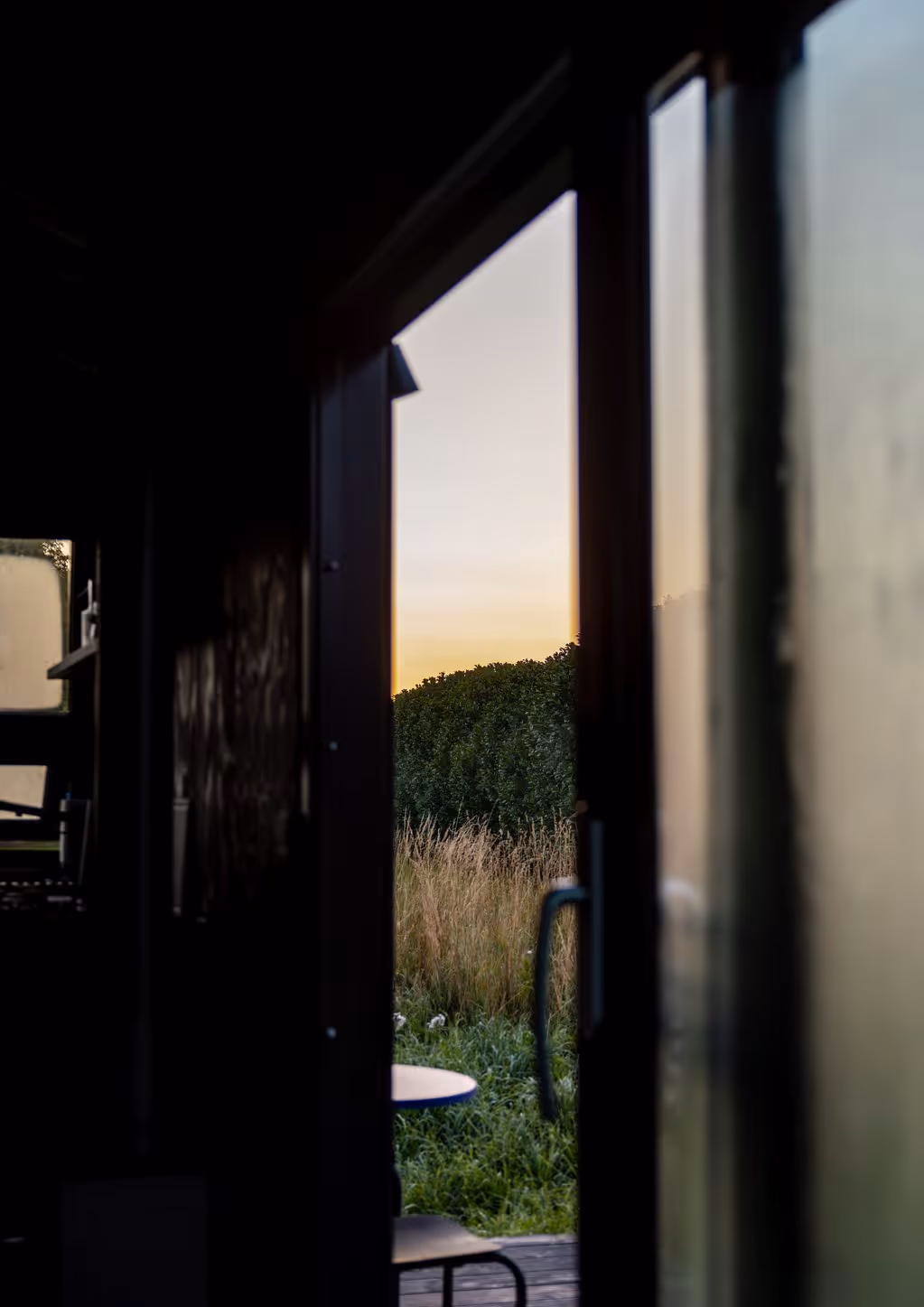 Blick von der NORI Cabin durch die große Schiebetür nach draußen in die Natur.