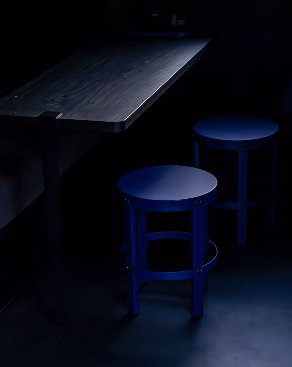 Blaue Küchenhocker von noo.ma in der schwarzen Designcabin von NORI